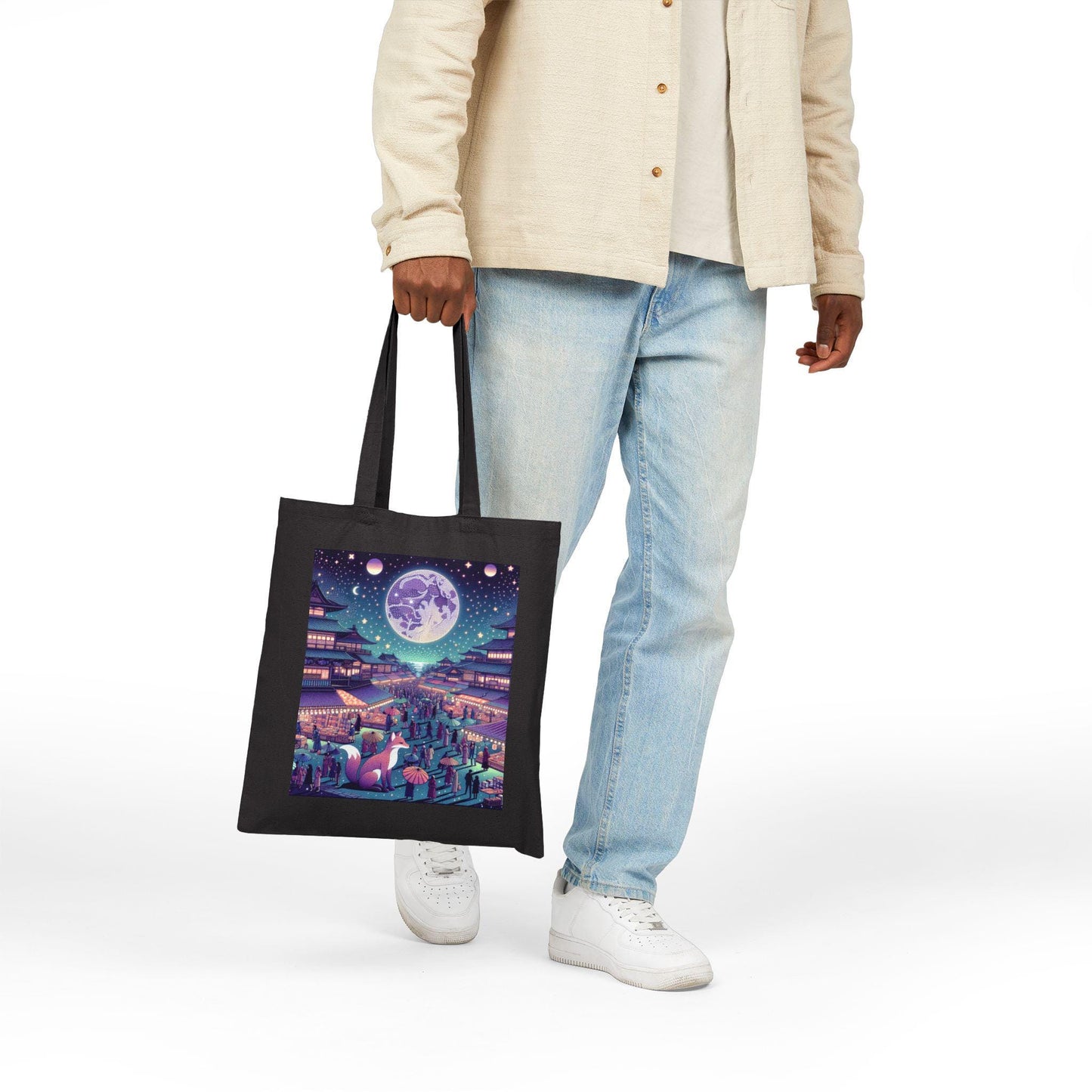 Person holding a tote bag with a colorful design of a cityscape at night.